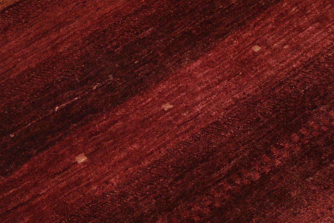 Handgeknoopt rood Loribaft-tapijt met ingewikkelde patronen.
