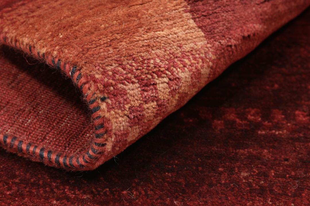 Handgeknoopt rood Loribaft-tapijt met ingewikkelde patronen.