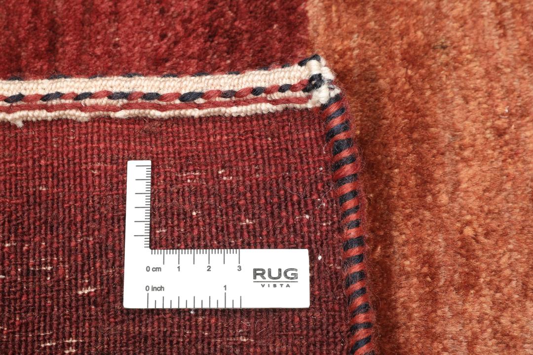 Handgeknoopt rood Loribaft-tapijt met ingewikkelde patronen.