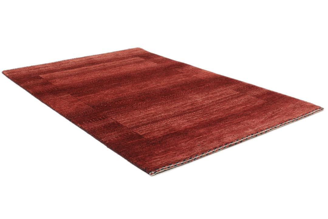 Een met de hand geknoopt rood Loribaft-tapijt uit het Midden-Oosten met een diepe, rijke kleur.