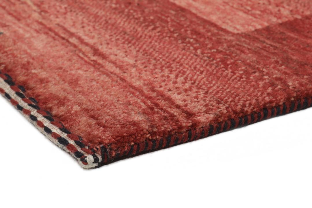 Een met de hand geknoopt rood Loribaft-tapijt uit het Midden-Oosten met een diepe, rijke kleur.