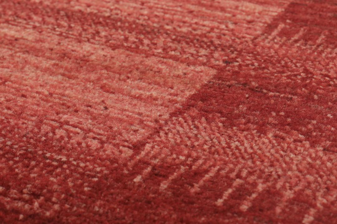 Een met de hand geknoopt rood Loribaft-tapijt uit het Midden-Oosten met een diepe, rijke kleur.