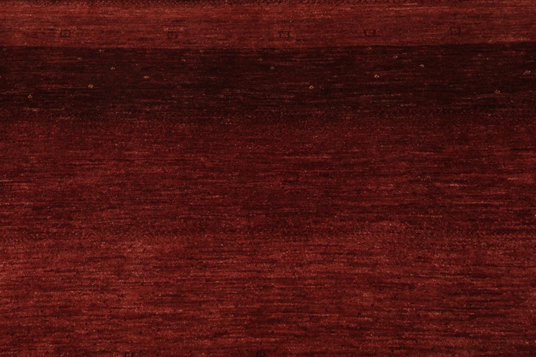 Een handgeknoopt Loribaft Fine tapijt uit het Midden-Oosten in een diepe donkerrode tint.