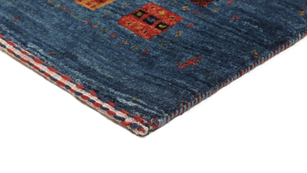 Een handgeknoopt Loribaft-kleed uit het Midden-Oosten met een blauw veld en kleurrijke vierkante motieven.