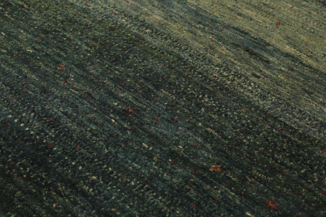 Hand-knotted Loribaft rug from the Middle East in deep forest green and earthy tones