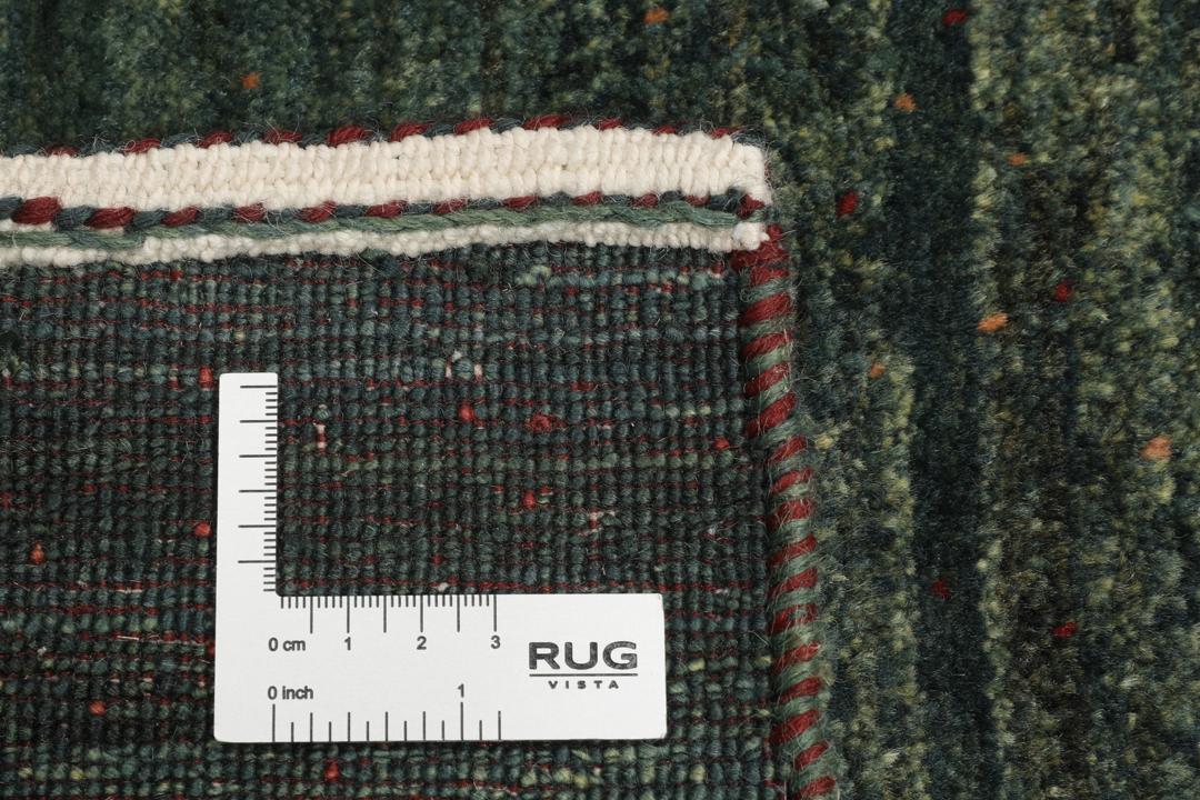 Hand-knotted Loribaft rug from the Middle East in deep forest green and earthy tones
