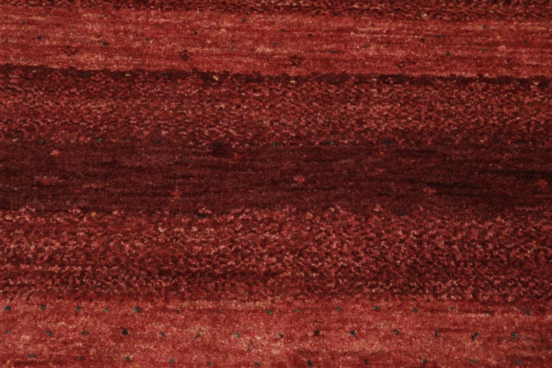 A hand-knotted Loribaft Fine rug from the Middle East in deep red tones.