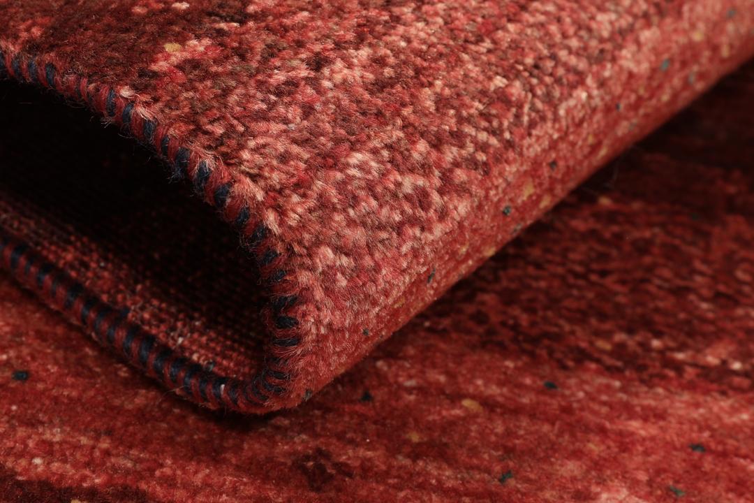 A hand-knotted Loribaft Fine rug from the Middle East in deep red tones.