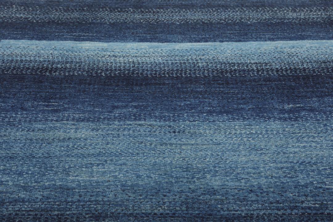 Håndknyttet Loribaft-tæppe med dybe blå toner og et tekstureret, minimalistisk design.