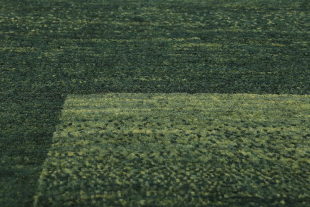 Håndknyttet Loribaft-tæppe fra Mellemøsten i dybe mørkegrønne toner.