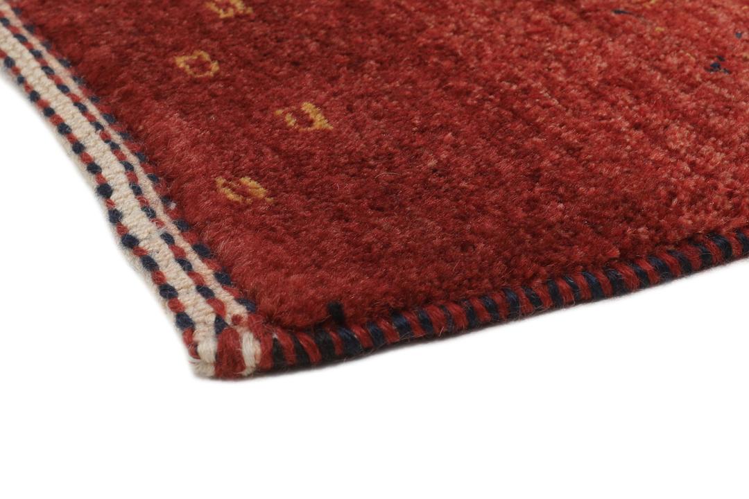 A hand-knotted Loribaft rug with earthy red, orange, and blue stripes from the Middle East