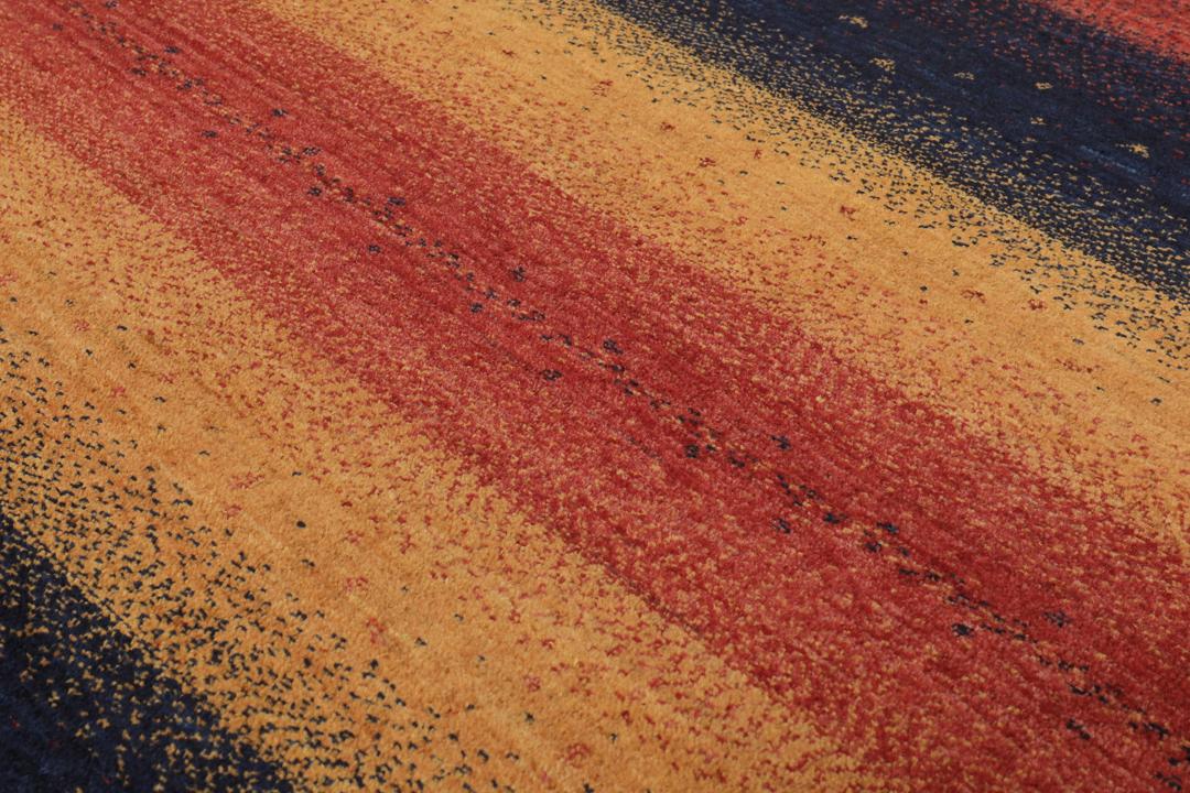 A hand-knotted Loribaft rug with earthy red, orange, and blue stripes from the Middle East