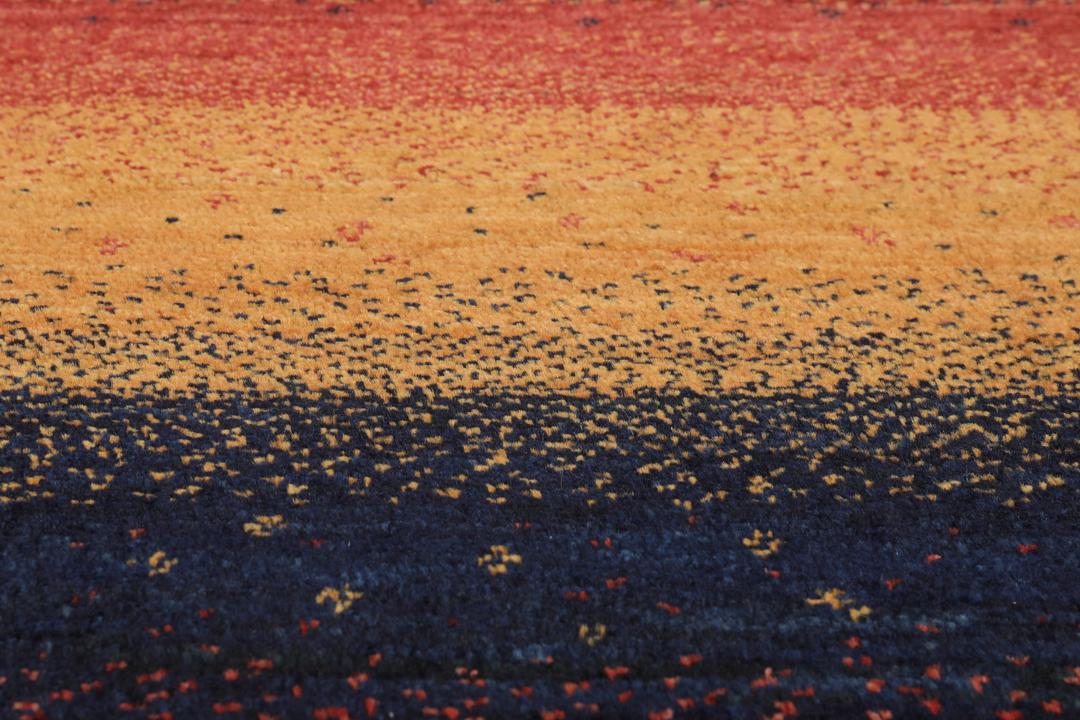 A hand-knotted Loribaft rug with earthy red, orange, and blue stripes from the Middle East