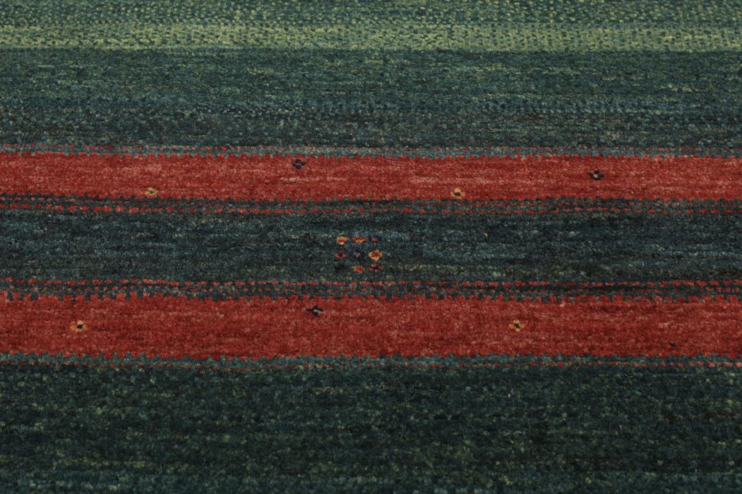 Handgeknoopt Loribaft-tapijt uit het Midden-Oosten in donkergroene en donkerrode tinten.