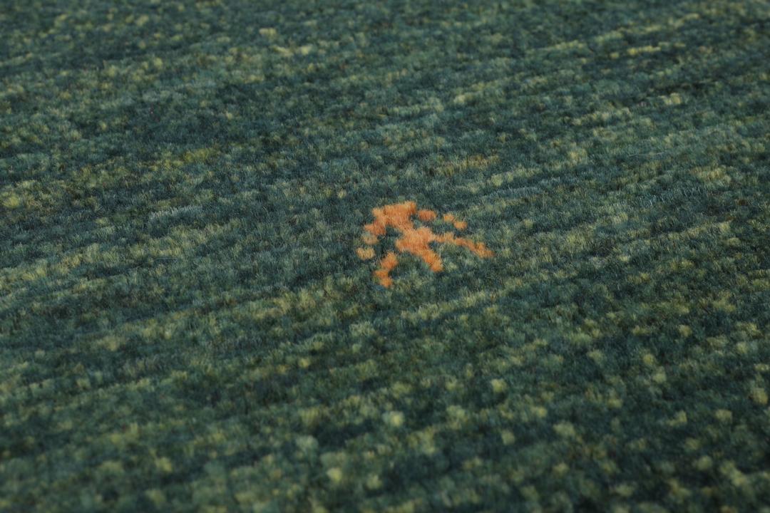 Handgeknoopt Loribaft-tapijt uit het Midden-Oosten in donkergroene en donkerrode tinten.