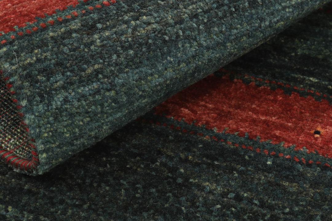 Handgeknoopt Loribaft-tapijt uit het Midden-Oosten in donkergroene en donkerrode tinten.