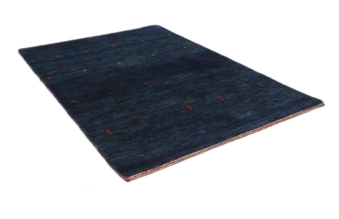 A hand-knotted Loribaft rug from the Middle East in a deep blue colour with small orange accents.