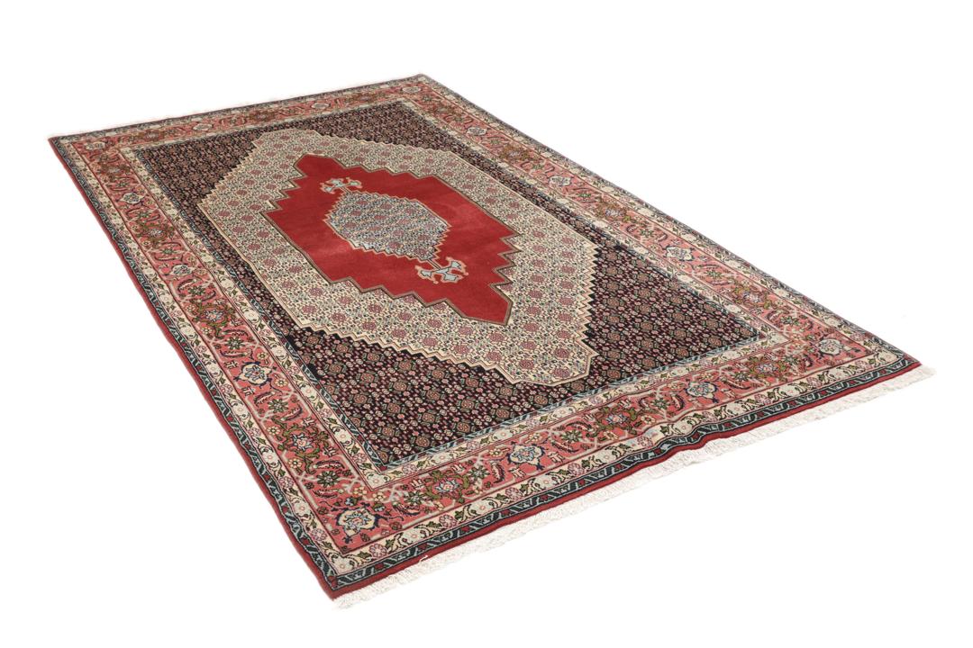 A hand-knotted Senneh rug from the Middle East featuring a dark-red and cream geometric medallion design.