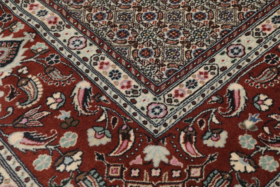 A hand-knotted Moud Wool rug from the Middle East in dark-red and beige tones.