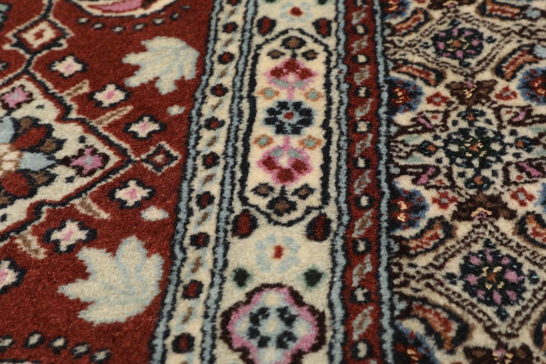 A hand-knotted Moud Wool rug from the Middle East in dark-red and beige tones.