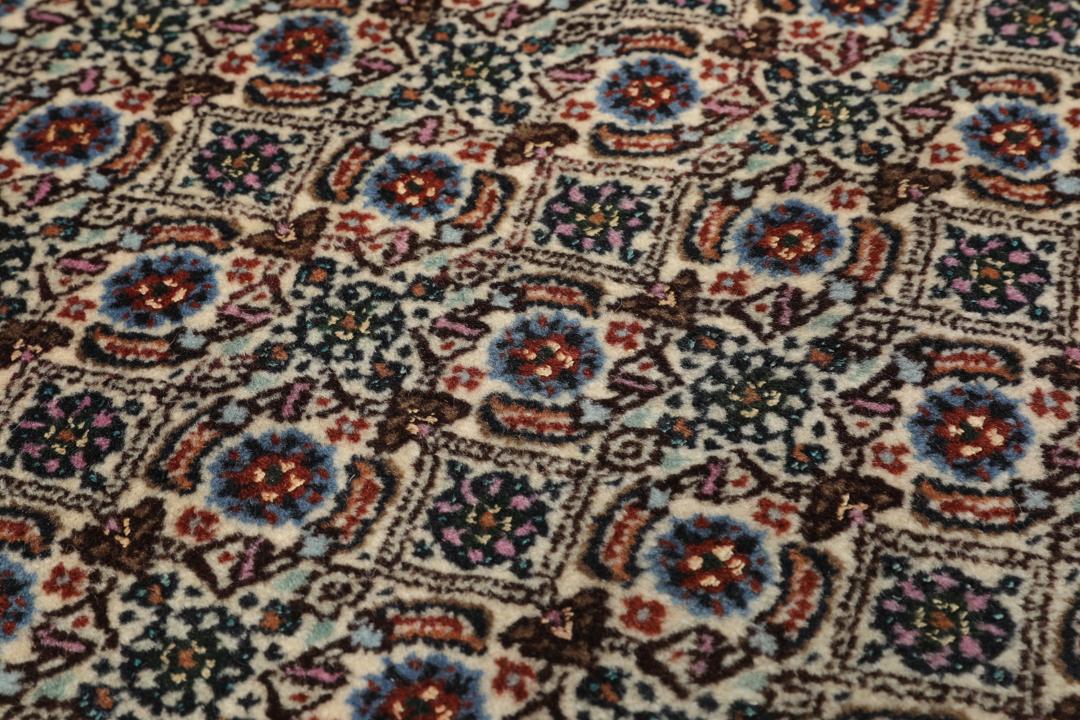 A hand-knotted Moud Wool rug from the Middle East in dark-red and beige tones.