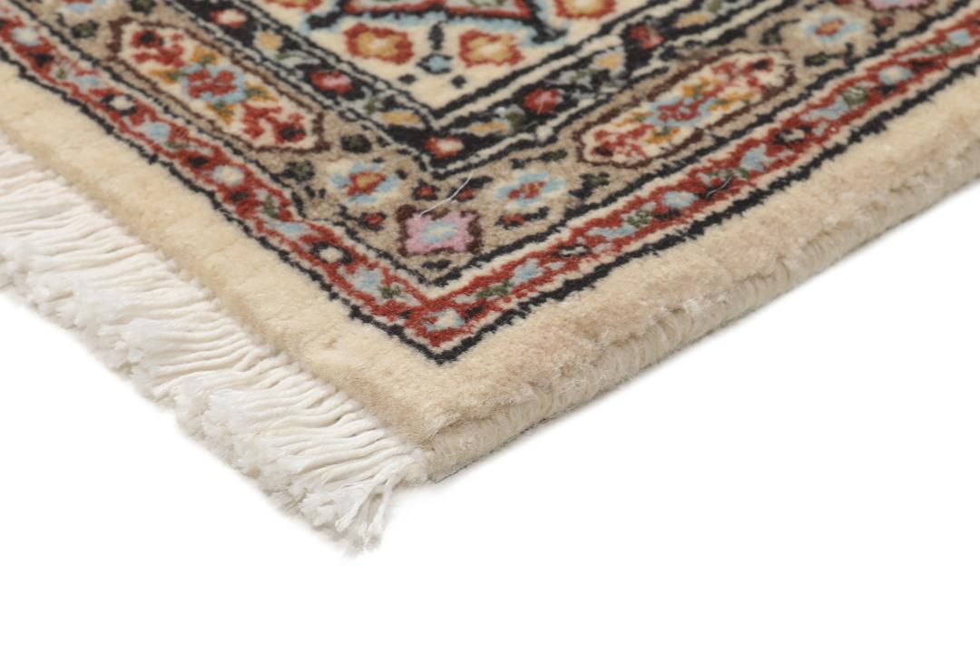 Een handgeknoopt Moud-tapijt uit het Midden-Oosten in beige, rode en blauwe tinten.