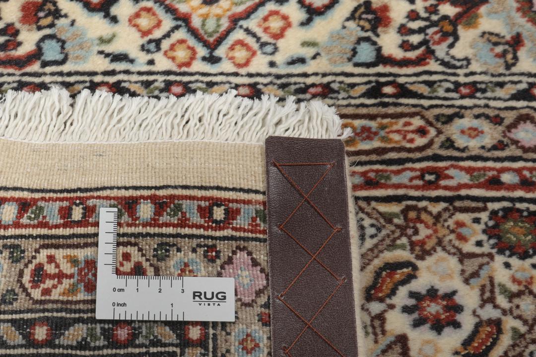 Een handgeknoopt Moud-tapijt uit het Midden-Oosten in beige, rode en blauwe tinten.