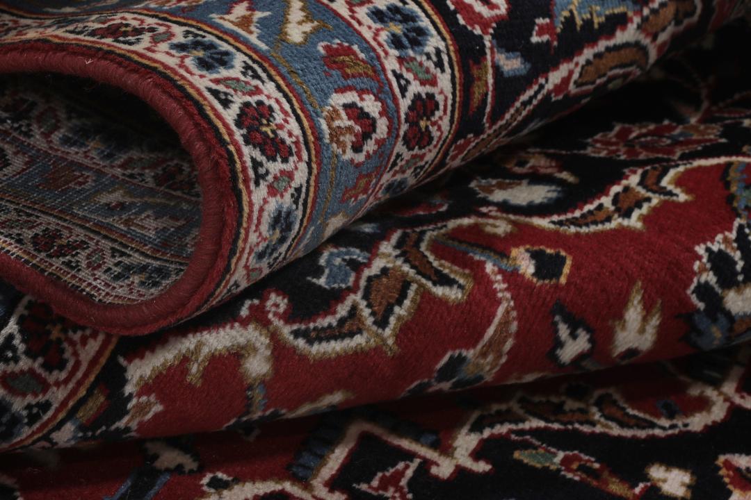 Een groot rechthoekig handgeknoopt Keshan-tapijt uit het Midden-Oosten in dieprode en blauwe tinten.