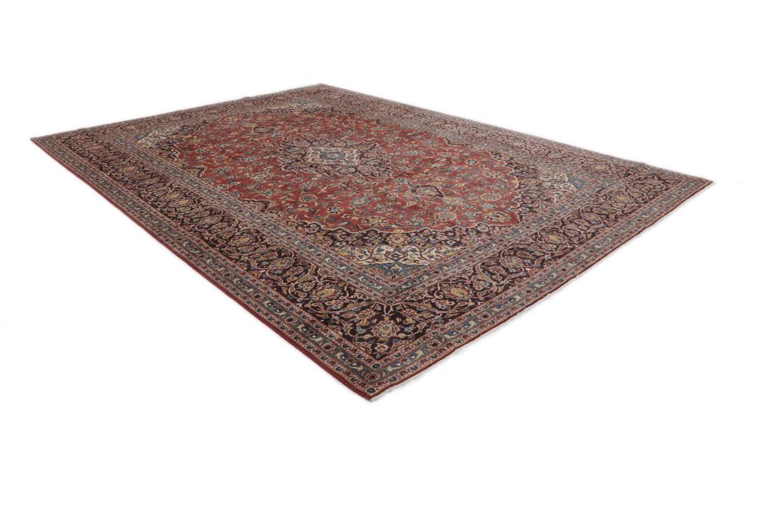 A large hand-knotted Keshan rug from the Middle East with a red floral pattern.