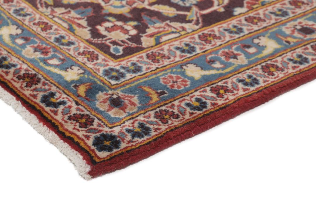 A large hand-knotted Keshan rug from the Middle East with a red floral pattern.