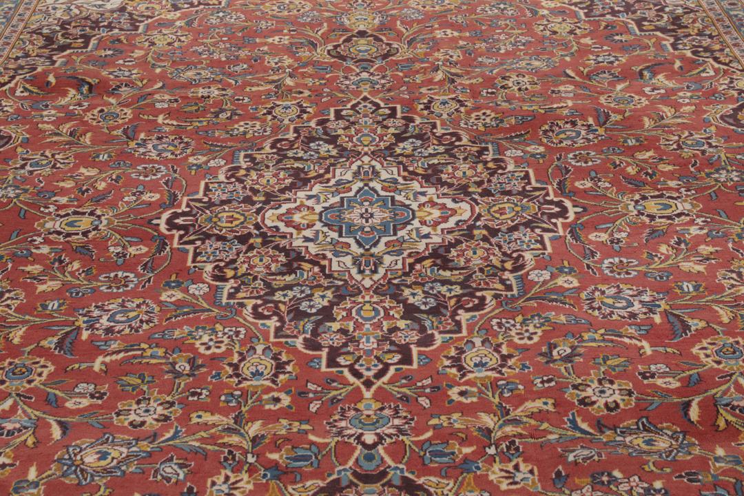 A large hand-knotted Keshan rug from the Middle East with a red floral pattern.