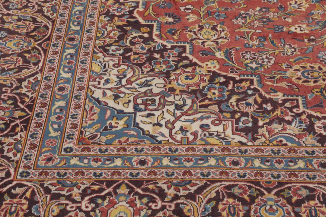 A large hand-knotted Keshan rug from the Middle East with a red floral pattern.