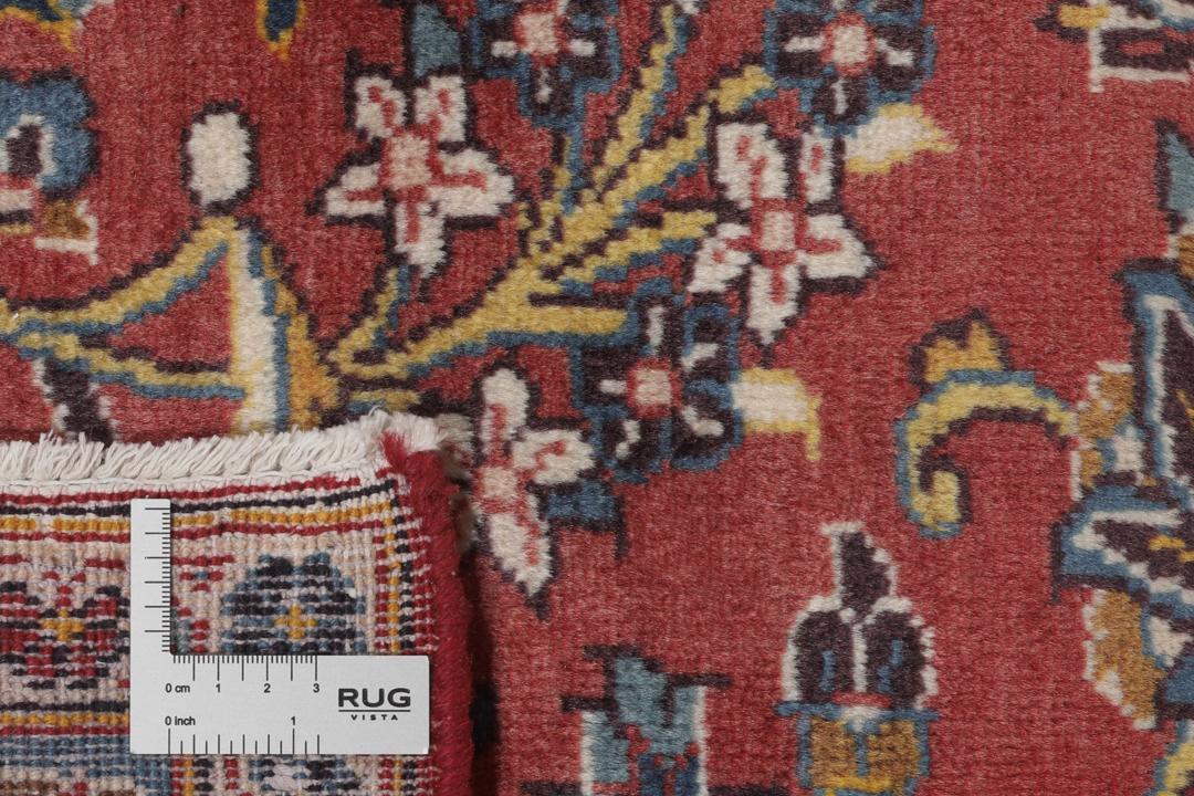 A large hand-knotted Keshan rug from the Middle East with a red floral pattern.