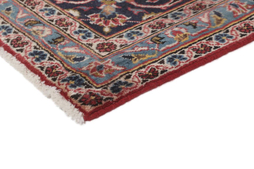 A hand-knotted Keshan rug from the Middle East with a red and dark-blue medallion pattern.