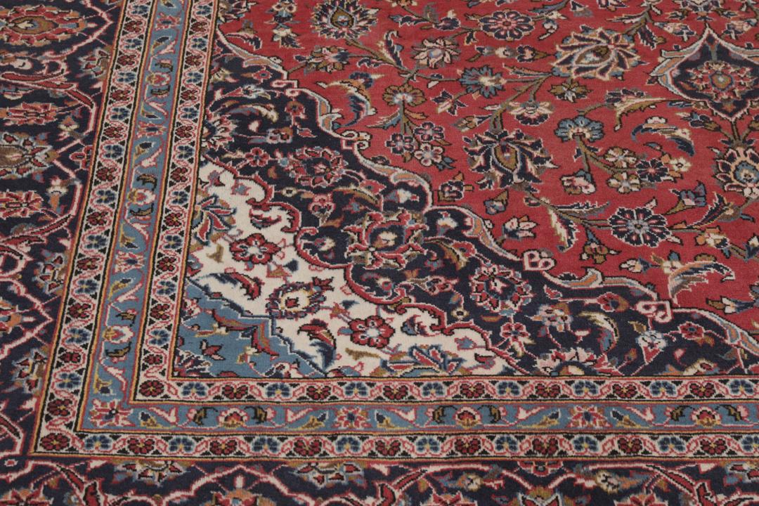 A hand-knotted Keshan rug from the Middle East with a red and dark-blue medallion pattern.