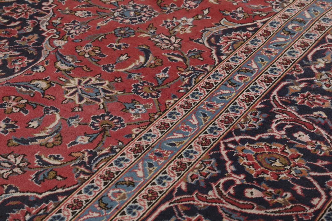 A hand-knotted Keshan rug from the Middle East with a red and dark-blue medallion pattern.