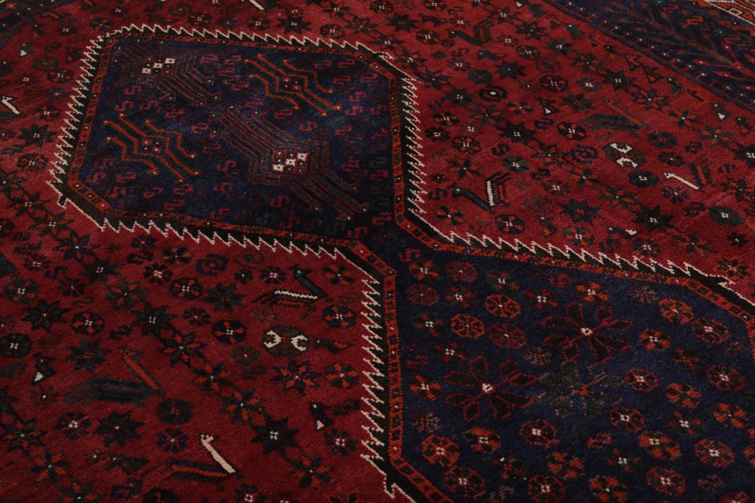 Hand-knotted Shiraz rug featuring deep blue and red tribal patterns