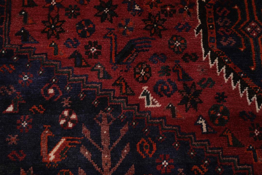 Hand-knotted Shiraz rug featuring deep blue and red tribal patterns