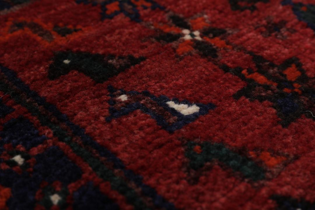 Hand-knotted Shiraz rug featuring deep blue and red tribal patterns