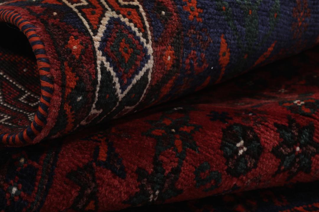 Hand-knotted Shiraz rug featuring deep blue and red tribal patterns