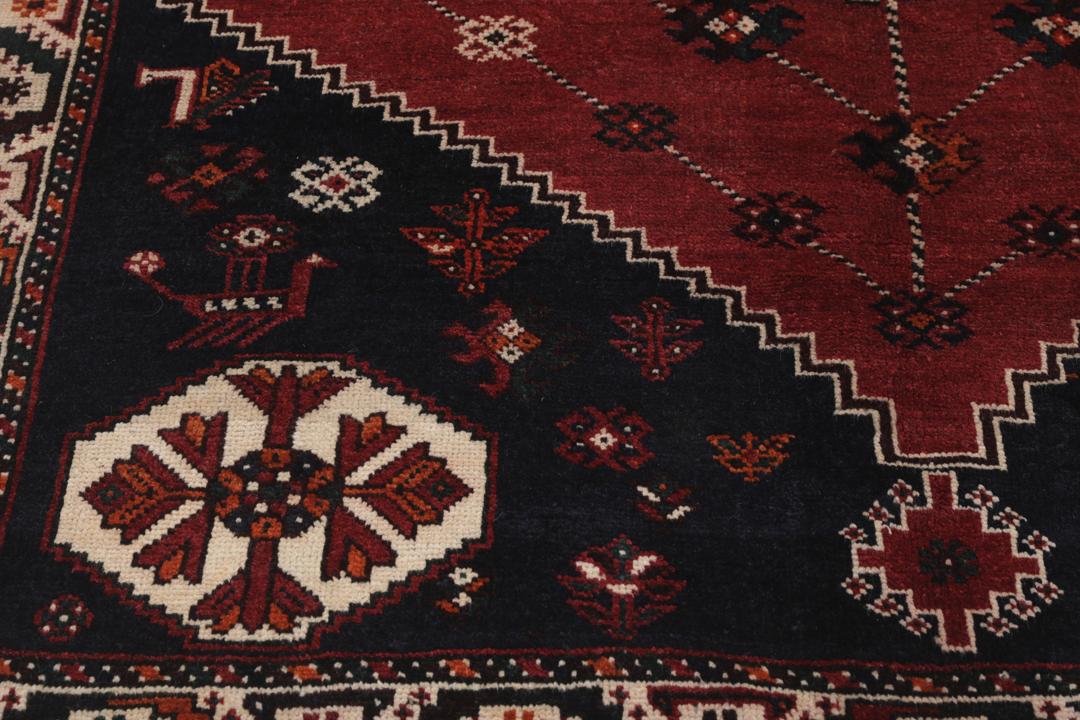 Hand-knotted Shiraz rug from the Middle East in dark-red and black tones.