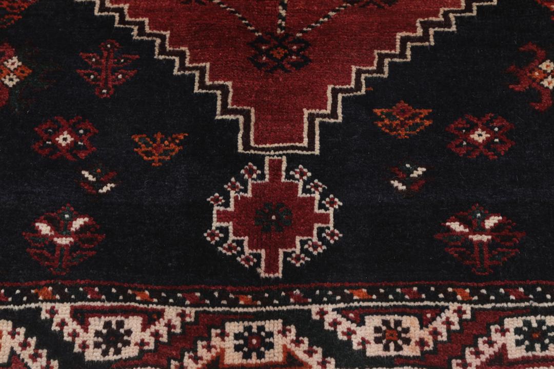 Hand-knotted Shiraz rug from the Middle East in dark-red and black tones.