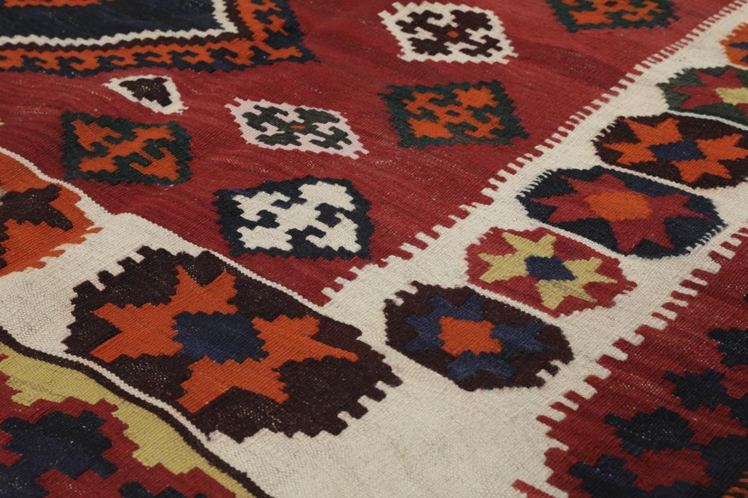 Tapis kilim vintage tissé à la main provenant du Moyen-Orient dans des tons rouge profond et géométriques contrastés