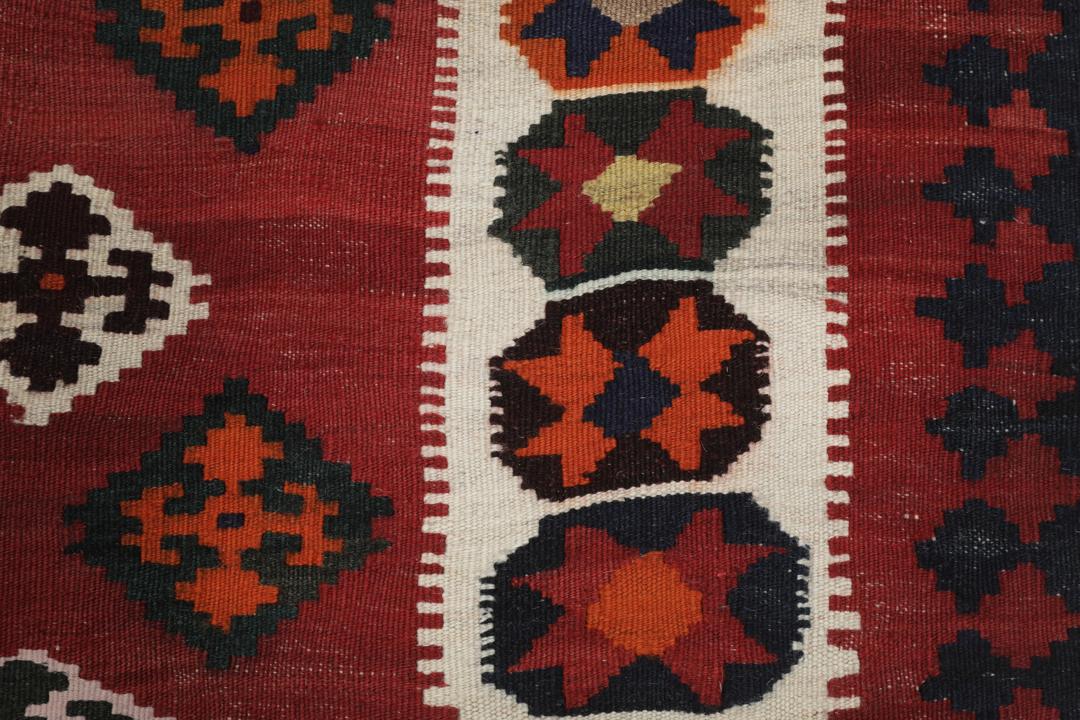 Tapis kilim vintage tissé à la main provenant du Moyen-Orient dans des tons rouge profond et géométriques contrastés