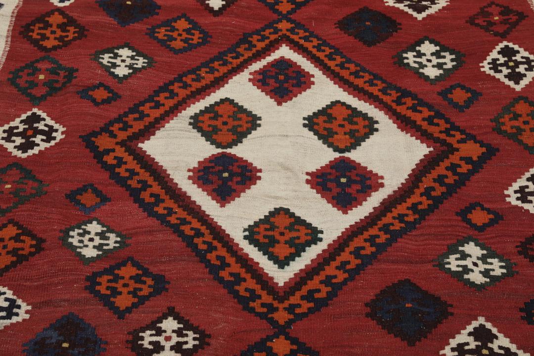 Tapis kilim vintage tissé à la main provenant du Moyen-Orient dans des tons rouge profond et géométriques contrastés