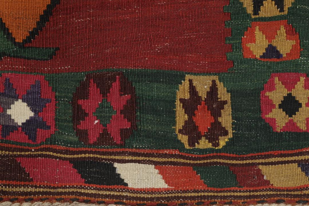 Un tapis kilim vintage tissé à la main provenant du Moyen-Orient, de couleur rouge profond avec des motifs géométriques