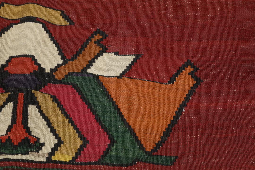 Un tapis kilim vintage tissé à la main provenant du Moyen-Orient, de couleur rouge profond avec des motifs géométriques