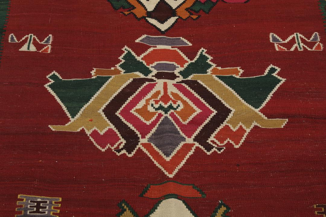Un tapis kilim vintage tissé à la main provenant du Moyen-Orient, de couleur rouge profond avec des motifs géométriques
