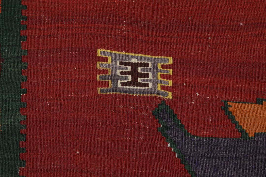 Un tapis kilim vintage tissé à la main provenant du Moyen-Orient, de couleur rouge profond avec des motifs géométriques