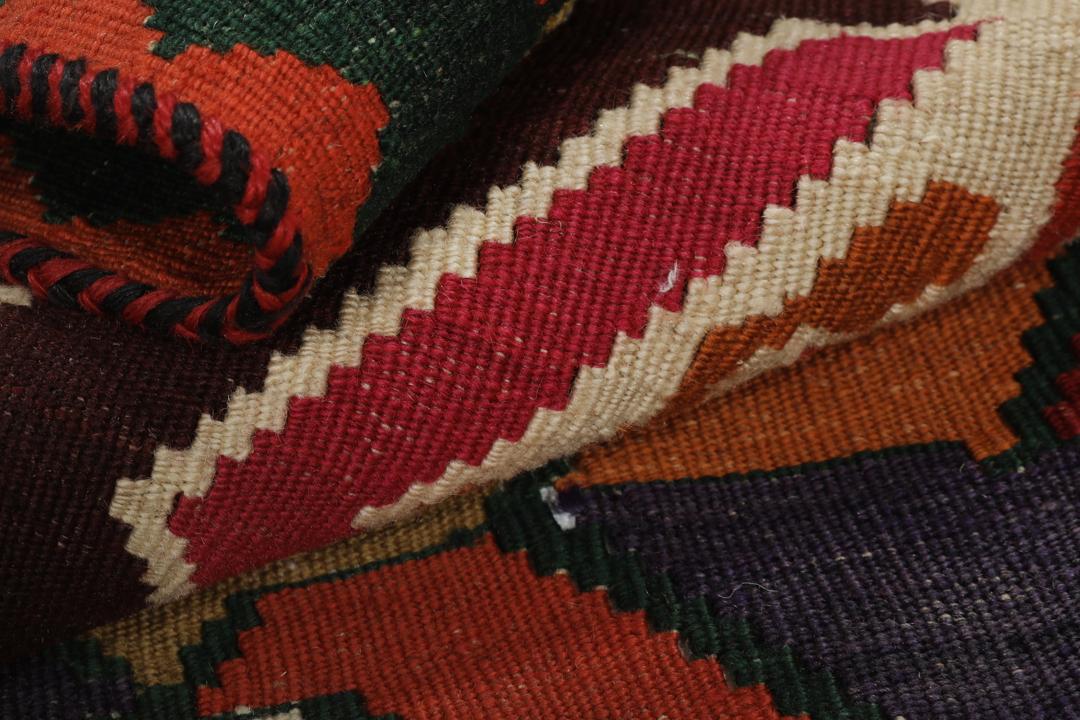 Un tapis kilim vintage tissé à la main provenant du Moyen-Orient, de couleur rouge profond avec des motifs géométriques